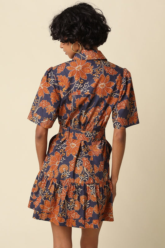 The Adele Floral Belted Mini Dress brings vintage-inspired charm to your wardrobe with a feminine fit-and-flare silhouette, button-front design, and playful tiered ruffle hem.
