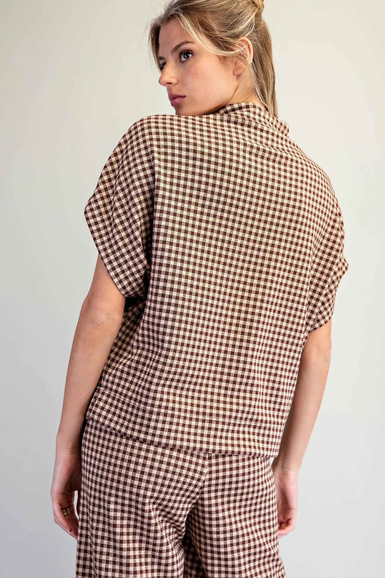 A relaxed gingham knit top featuring a modern mock neckline, wide dolman sleeves, and an effortlessly chic oversized silhouette.