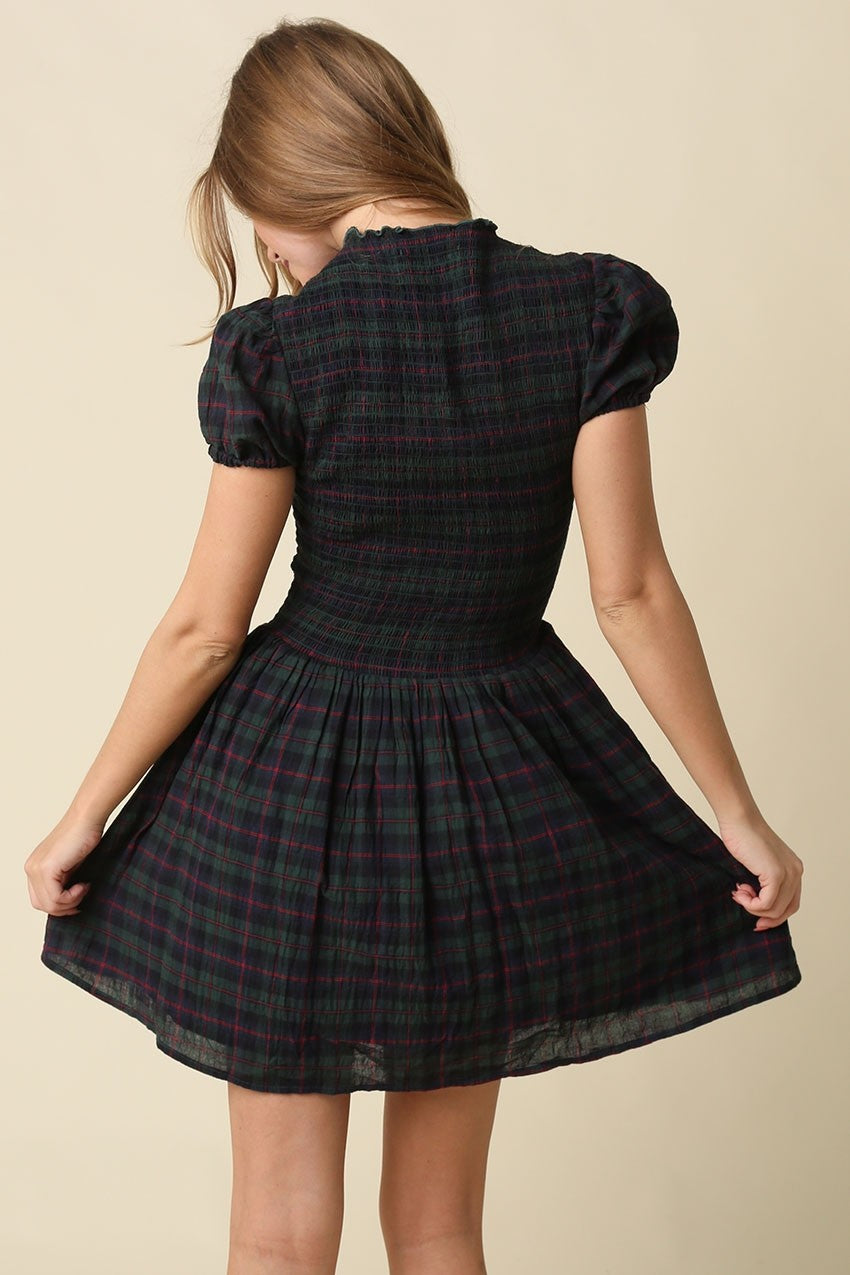 A timeless plaid mini dress featuring a flattering smocked bodice, feminine cap sleeves, and a softly gathered fit-and-flare skirt in breathable cotton.