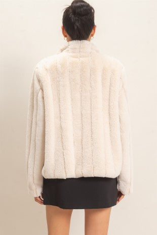 A luxurious faux fur jacket featuring a clean silhouette, cozy warmth, functional pockets, and an easy hook-and-eye front closure.

