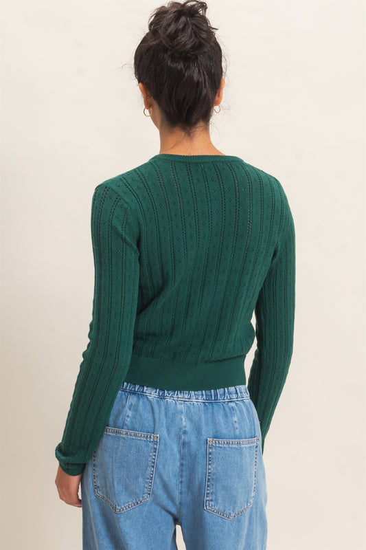 A timeless pointelle knit cardigan featuring a classic button-front design, ribbed crew neckline, and a tailored silhouette for effortless everyday elegance.