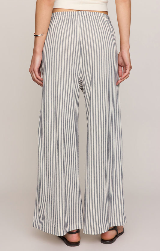 Women’s high-rise wide-leg ankle pants in silky stretch knit fabric with elastic waistband, slash pockets, lightweight design, and ultra-soft finish.