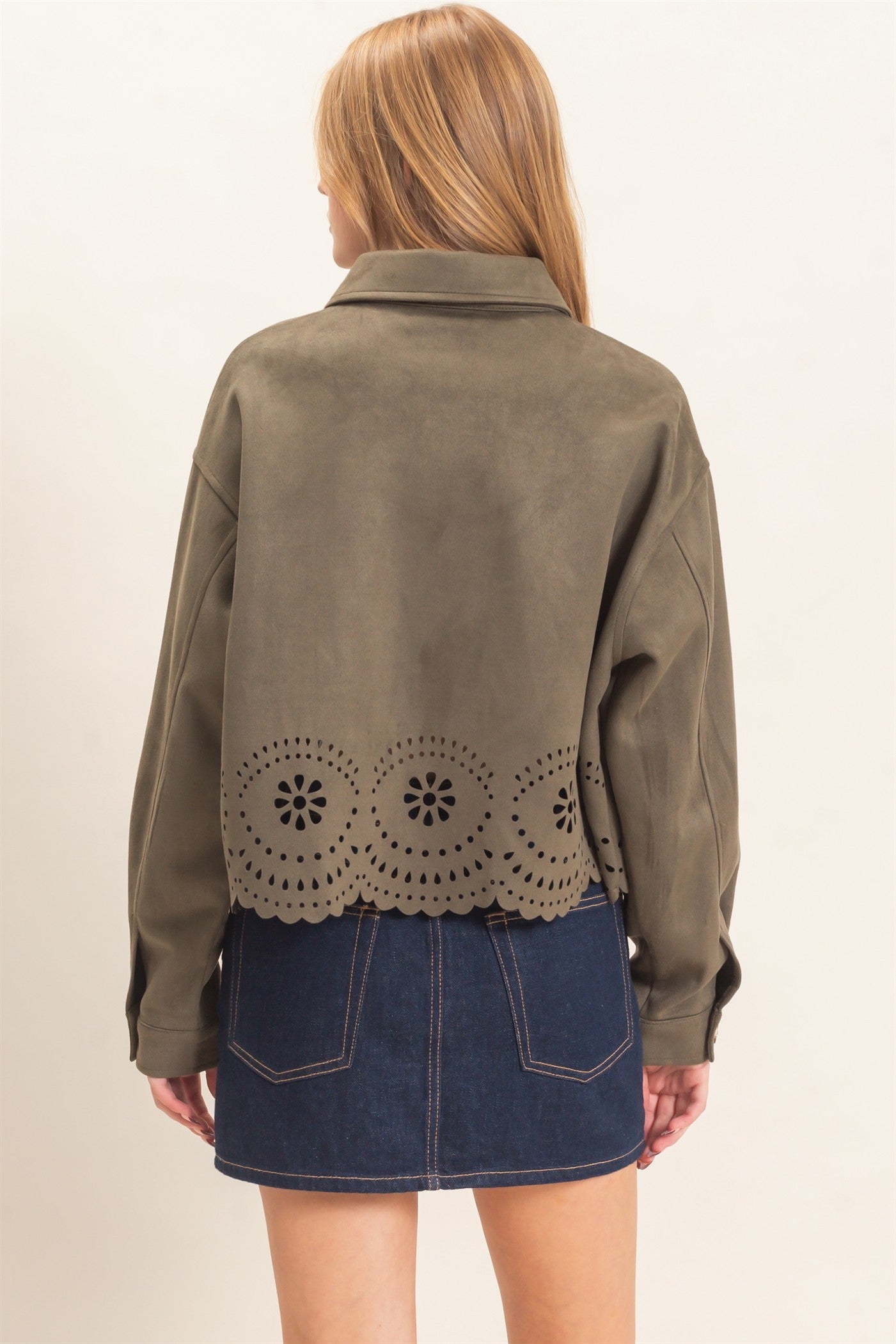 A beautifully structured suede jacket with button-front styling, chest pockets, relaxed drop shoulders, and an intricate laser-cut floral hem.