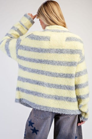 A cozy textured knit cardigan featuring a relaxed slouchy fit, dropped shoulders, and playful mismatched buttons for a unique finishing touch.
