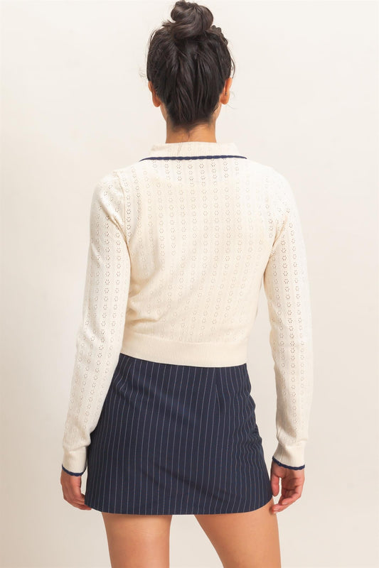 A refined pointelle knit cardigan featuring a classic point collar, contrast trim, and a timeless button-front design for effortless everyday elegance.