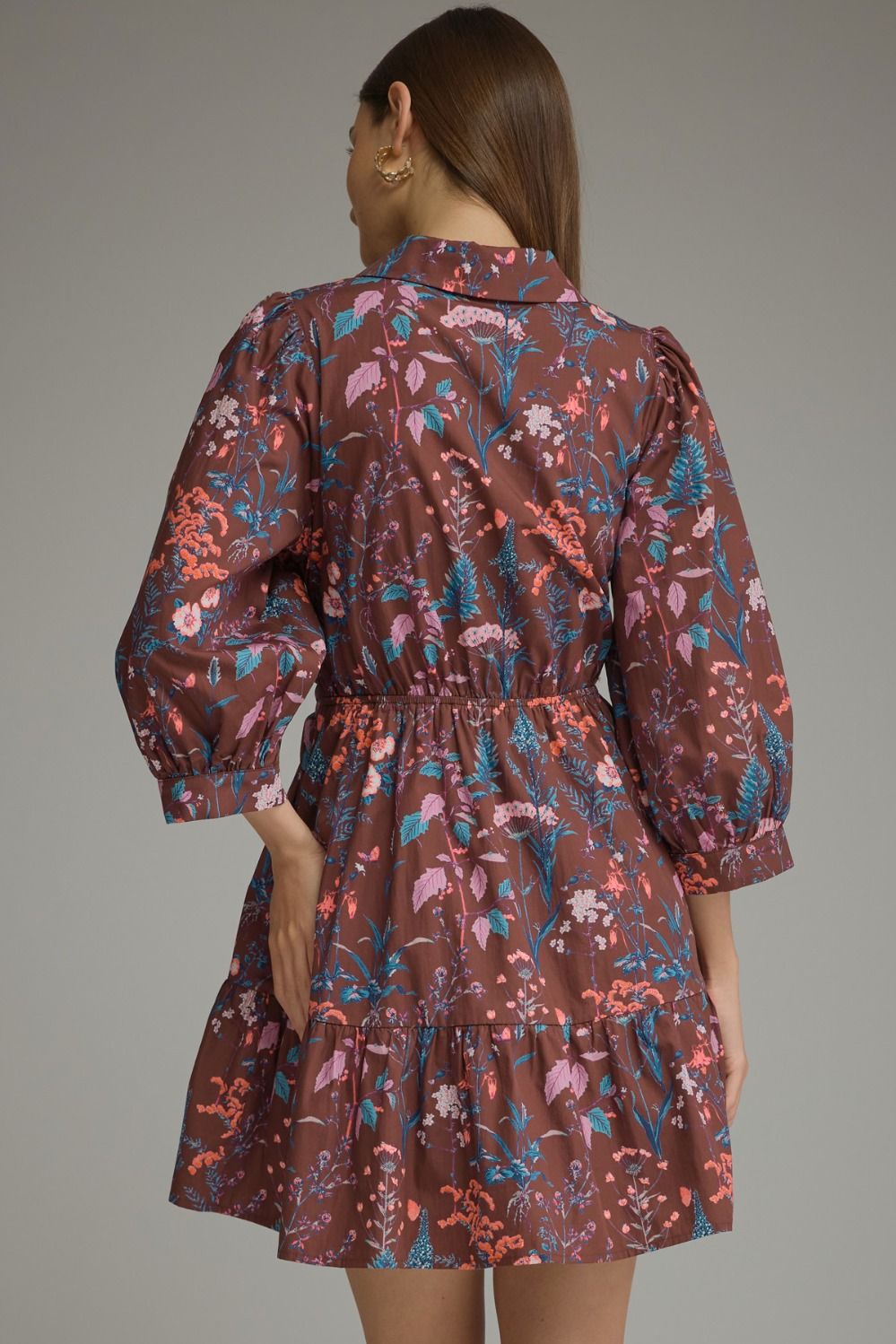 A charming floral mini dress featuring ¾ balloon sleeves, a classic shirt collar, self-tie waist, and playful tiered hem.
