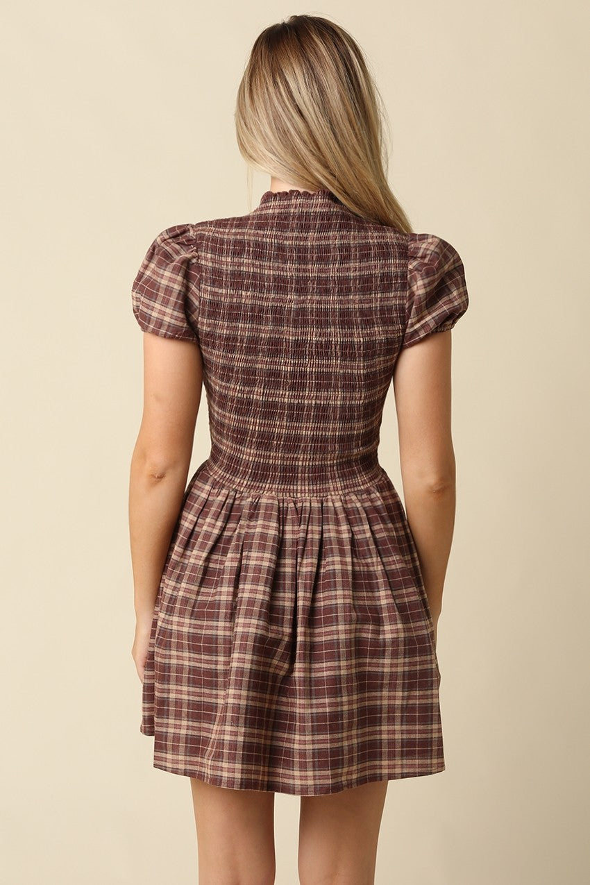 The Rebecca Plaid Smocked Mini Dress pairs timeless plaid with a flattering fit-and-flare silhouette, delicate ruffle sleeves, and a softly gathered skirt.