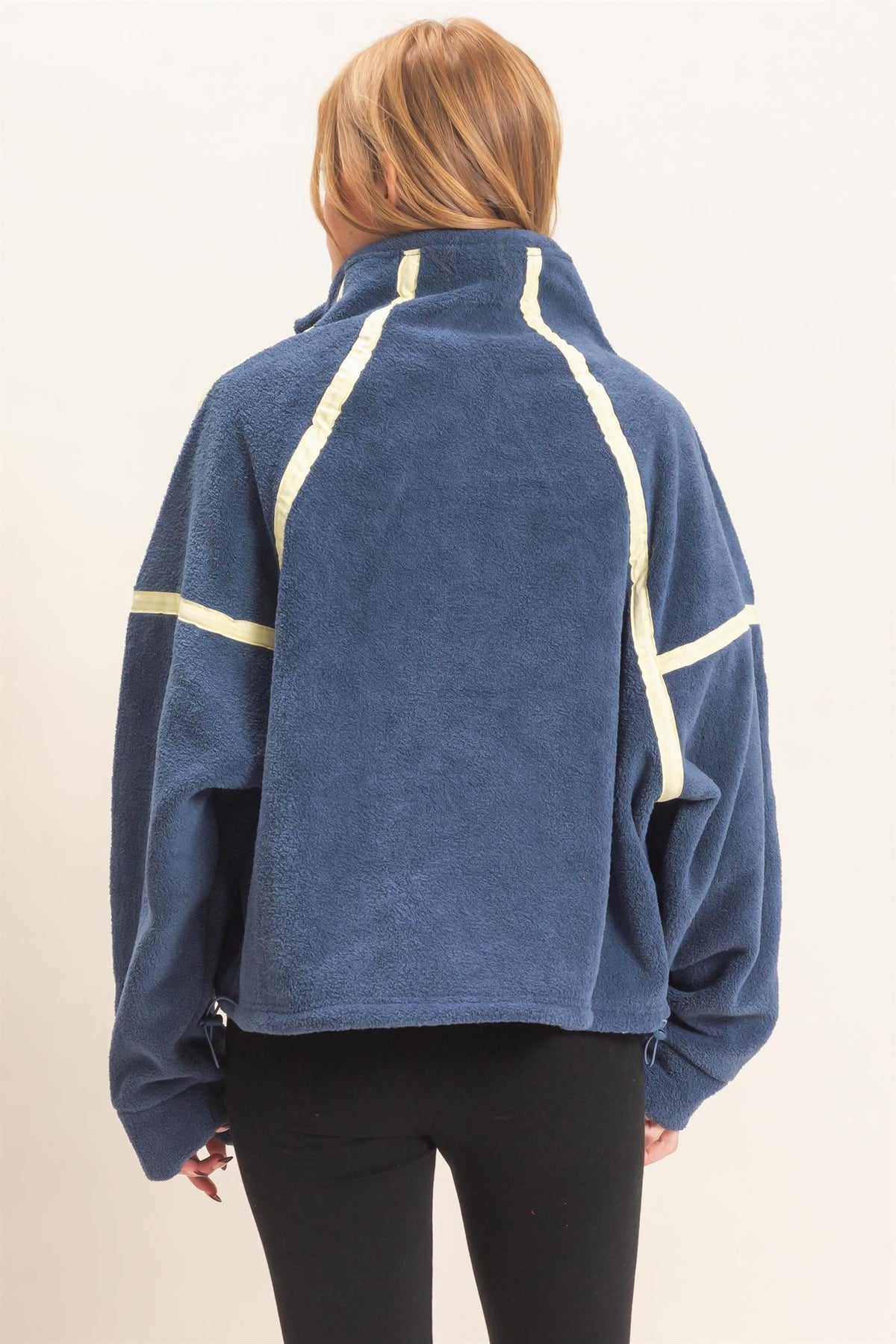 A cozy fleece pullover featuring a high funnel neck, sporty contrast trim, oversized curved pockets, and an adjustable drawstring hem.