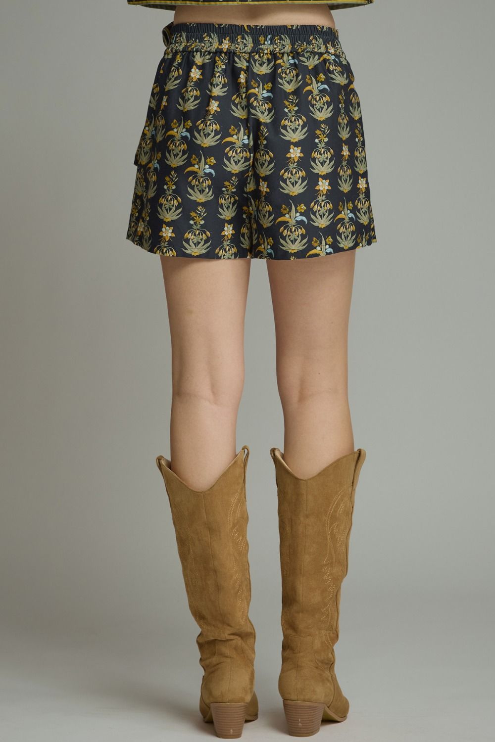 A feminine floral two-piece set featuring a flattering a contrast-trimmed V-neck top and coordinating wrap-front mini skort for an effortlessly polished boutique look.

