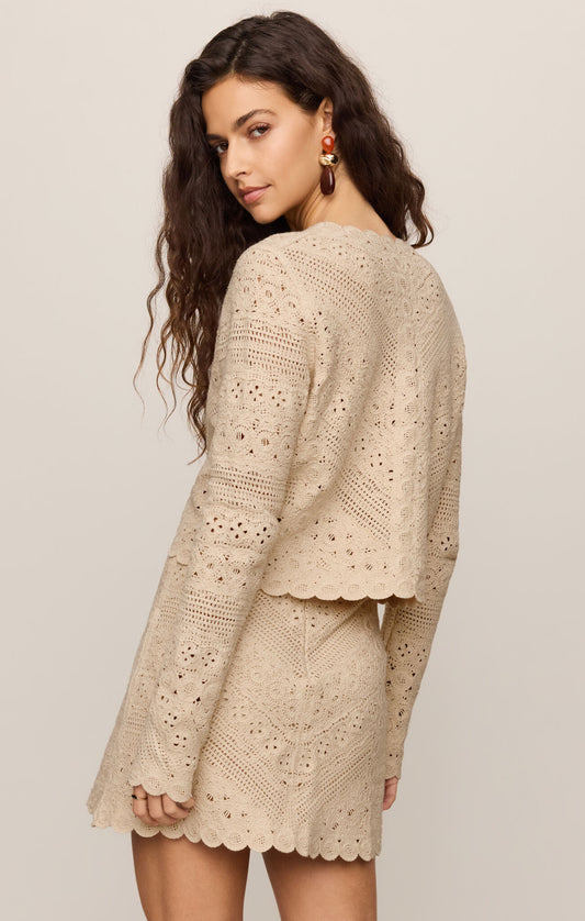 a beige crochet cardigan with crew neckline and covered buttons,long sleeves 