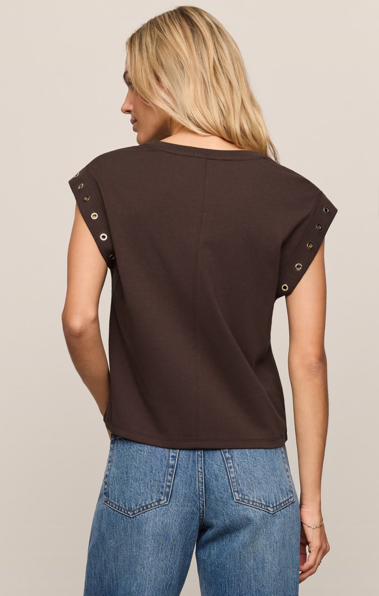back of a brown sleeveless top with grommet trim on short sleeve 