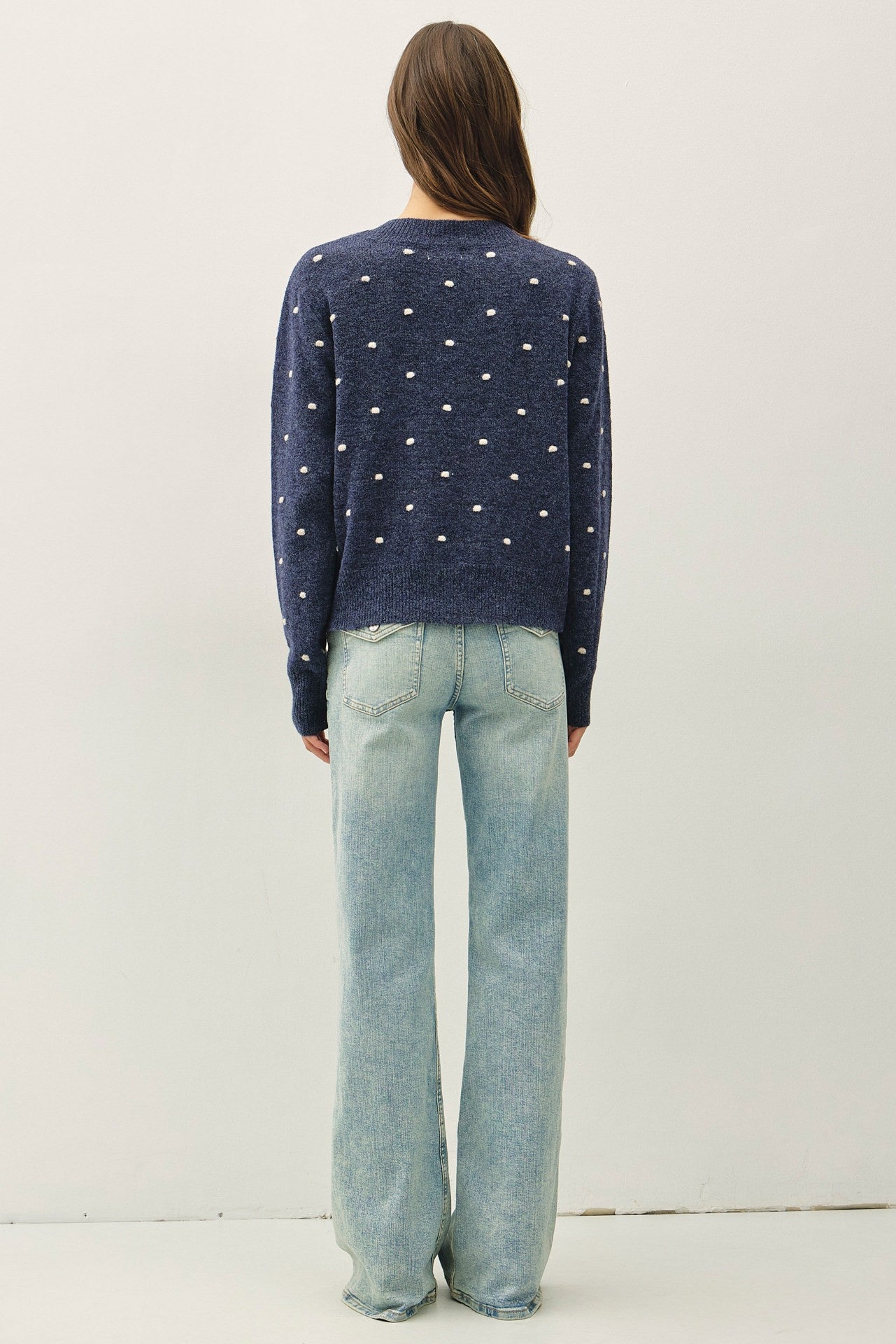 back of navy blue knit sweater with white polka dots 