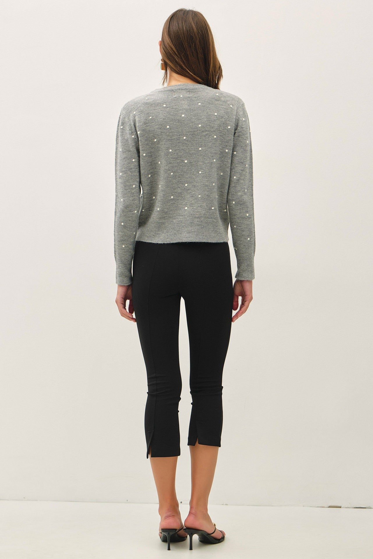 back of a light gray knit cardigan with small white embroidered dots and button-front closure, crew neckline,