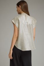 A chic sleeveless-inspired cap sleeve top featuring a high neckline and statement oversized bow for an effortlessly feminine finish.

