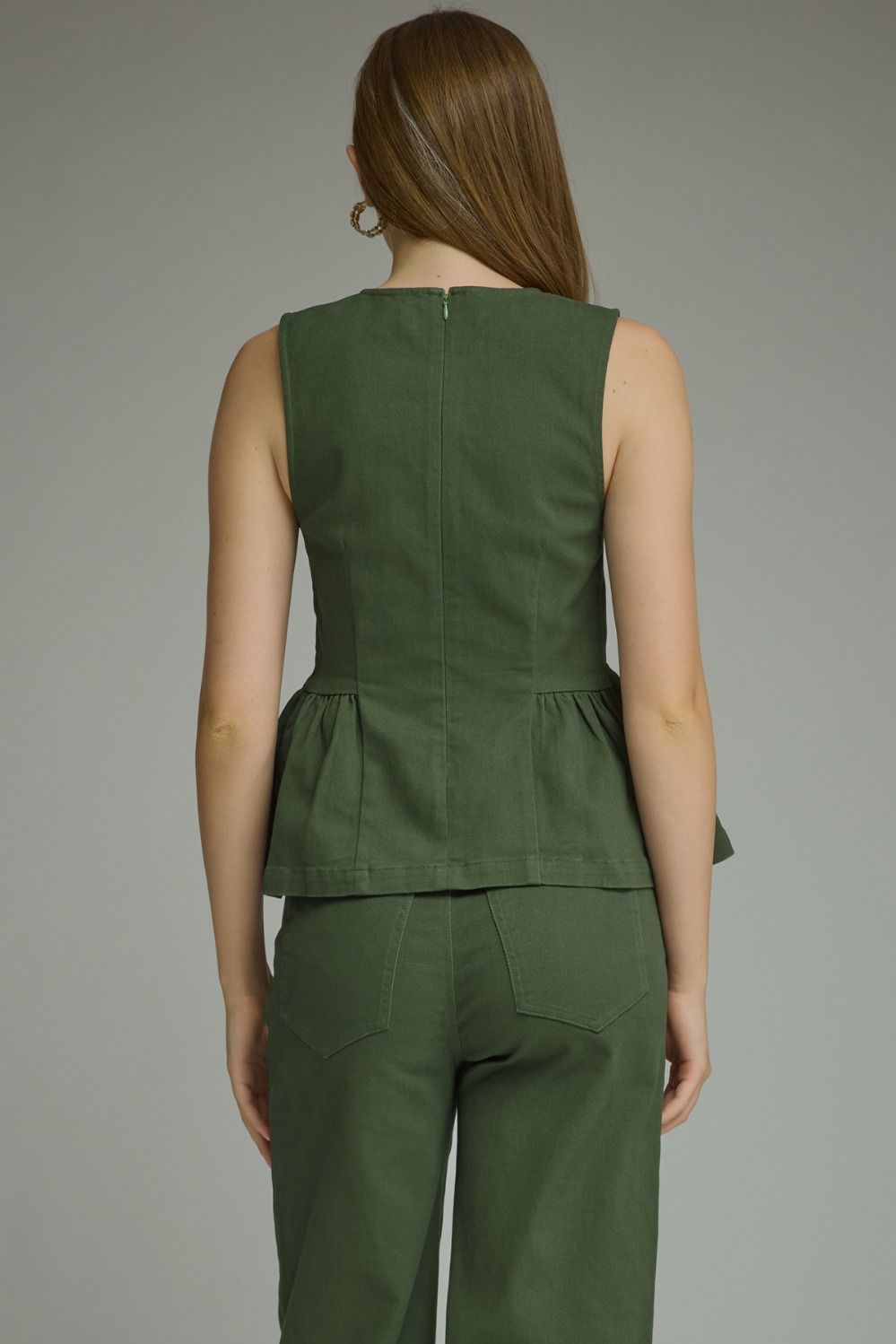A timeless sleeveless peplum top featuring a flattering silhouette, clean lines, and lightweight woven fabric for effortlessly polished style.