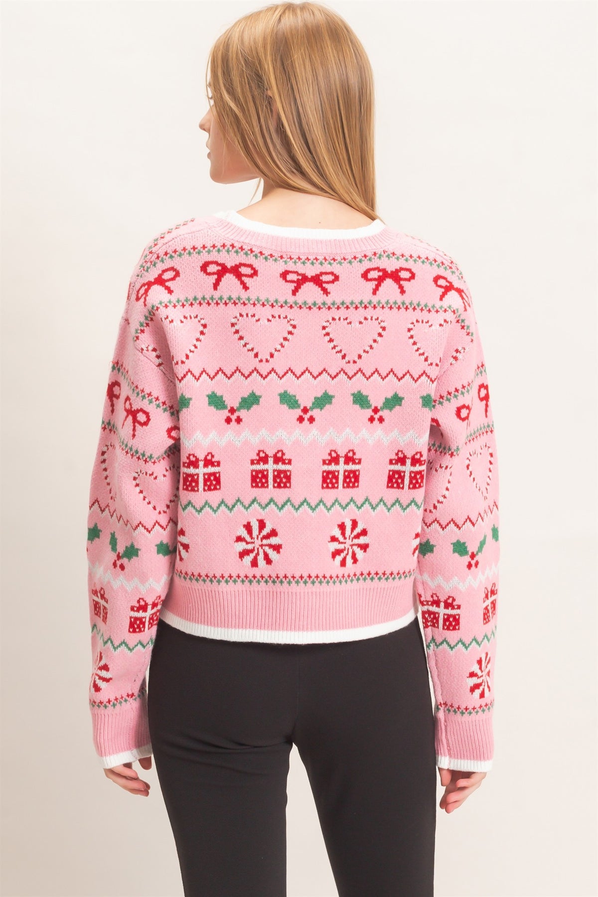 A festive cropped cardigan featuring a charming holiday jacquard pattern, classic button front, and polished contrast edging.

