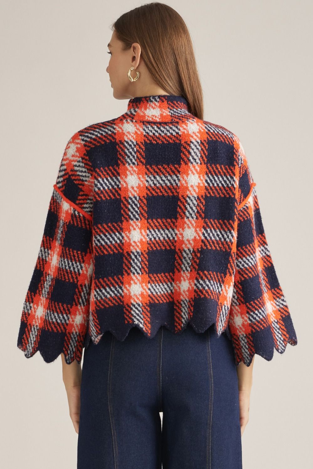 The Winifred Plaid Scalloped Hem Sweater Top brings classic plaid charm to a cozy knit silhouette finished with a feminine high neckline and scalloped hem.


