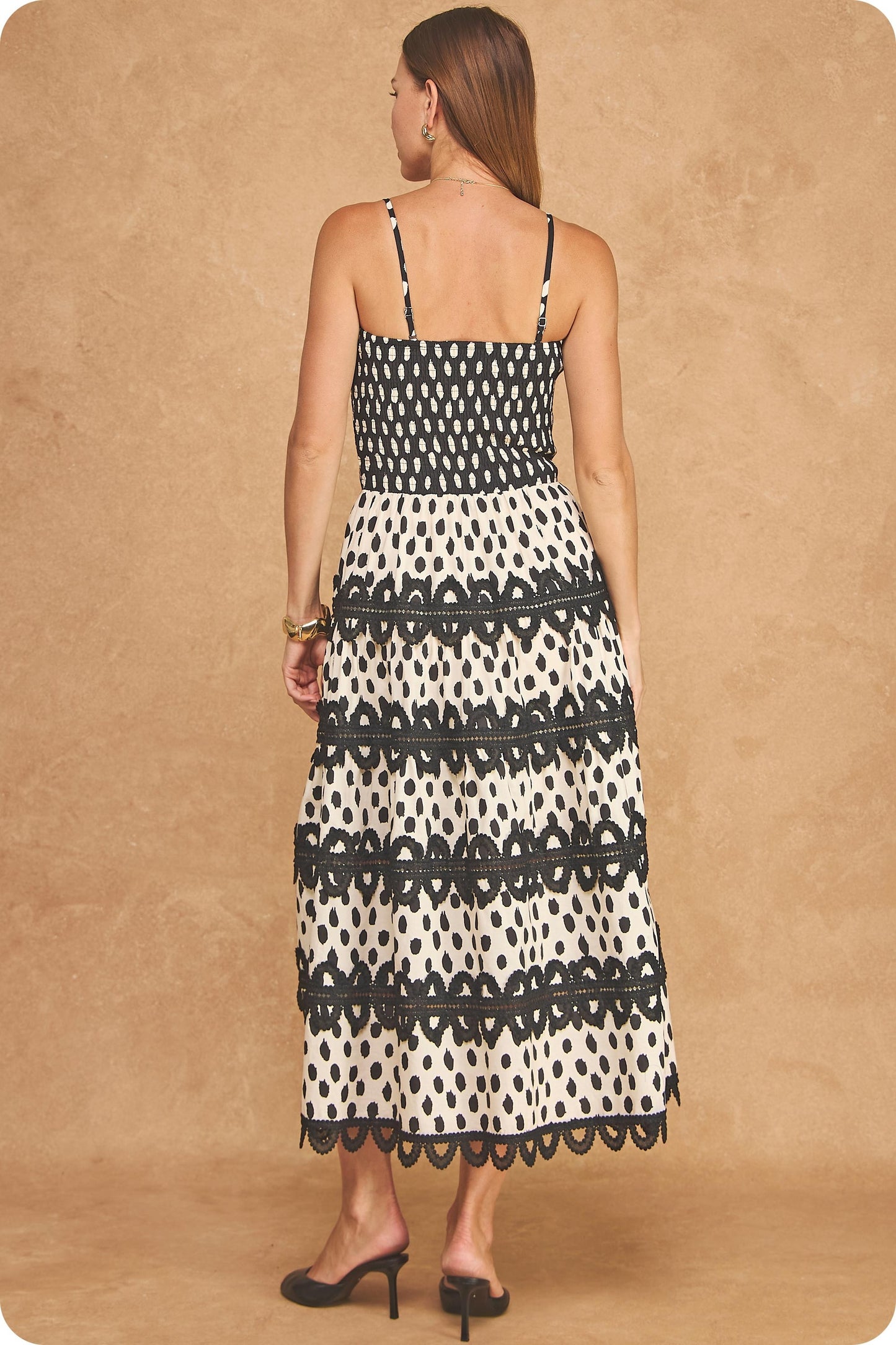 A stunning cotton midi dress featuring an abstract dot print, smocked bodice, adjustable straps, and crochet lace trim detailing for effortless bohemian elegance.