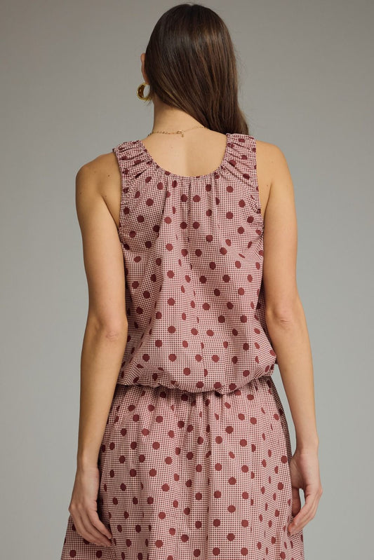 A charming gingham polka dot sleeveless top featuring a gathered neckline, elastic hem, and lightweight lined design for effortless feminine style.
