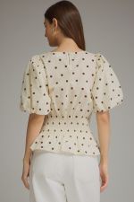 The Claudette Polka Dot Peplum Top brings playful vintage-inspired charm to your wardrobe with puff sleeves, a smocked waist, and a feminine ruffle hem.
