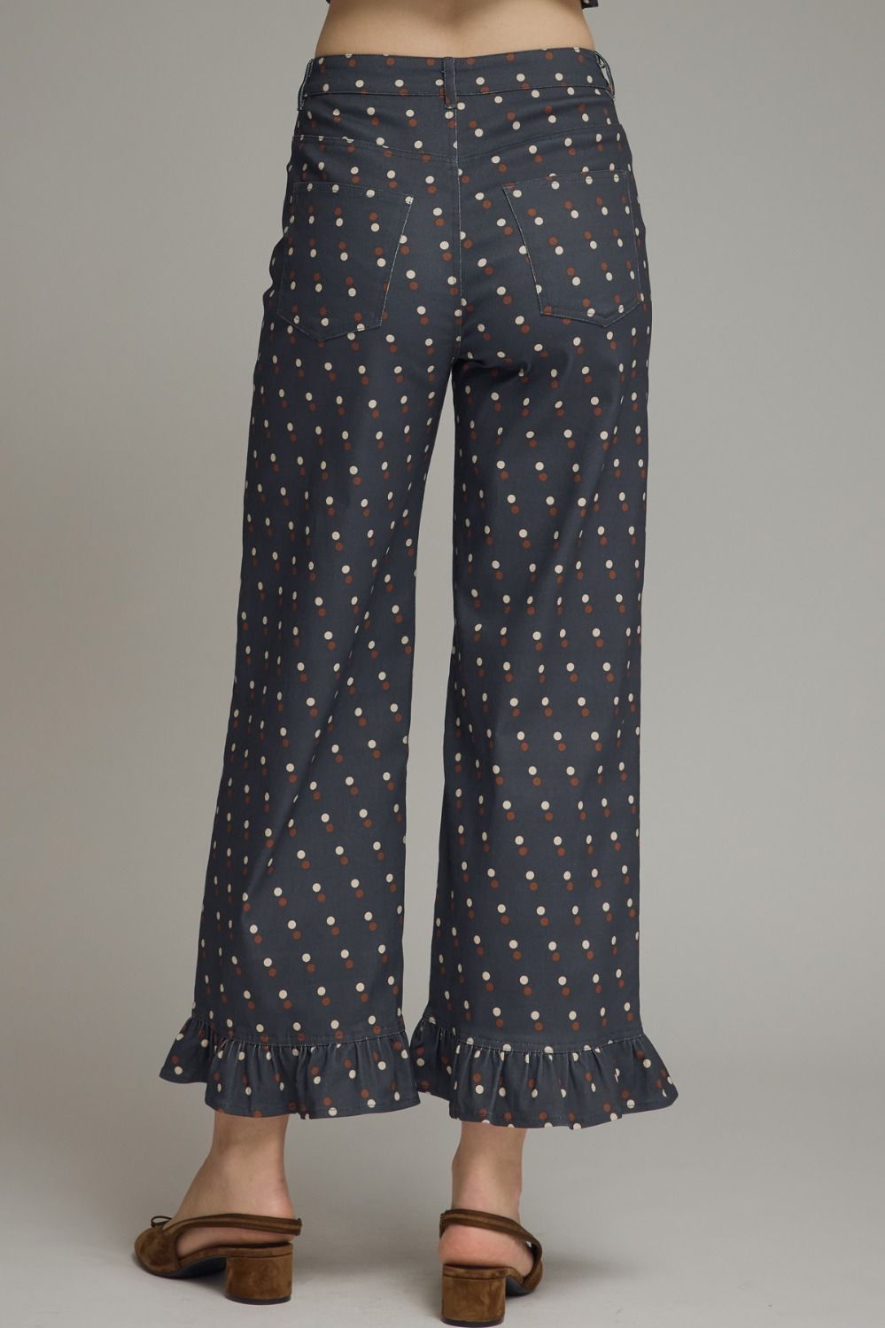 Make every outfit memorable with these playful polka dot denim pants featuring a flattering straight-leg silhouette and feminine ruffle hems.