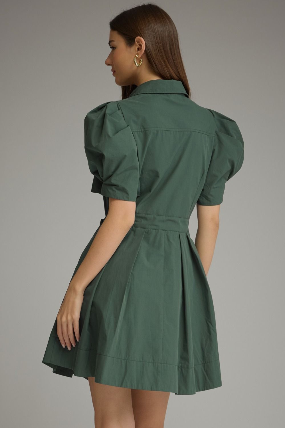 A feminine mini dress featuring playful puff sleeves, a classic shirt collar, waist tie detail, and a beautifully pleated skirt.


