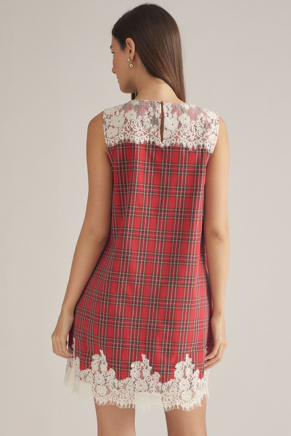 A charming plaid mini dress featuring a delicate lace yoke, lace-trimmed hem, and convenient side pockets for feminine everyday style.