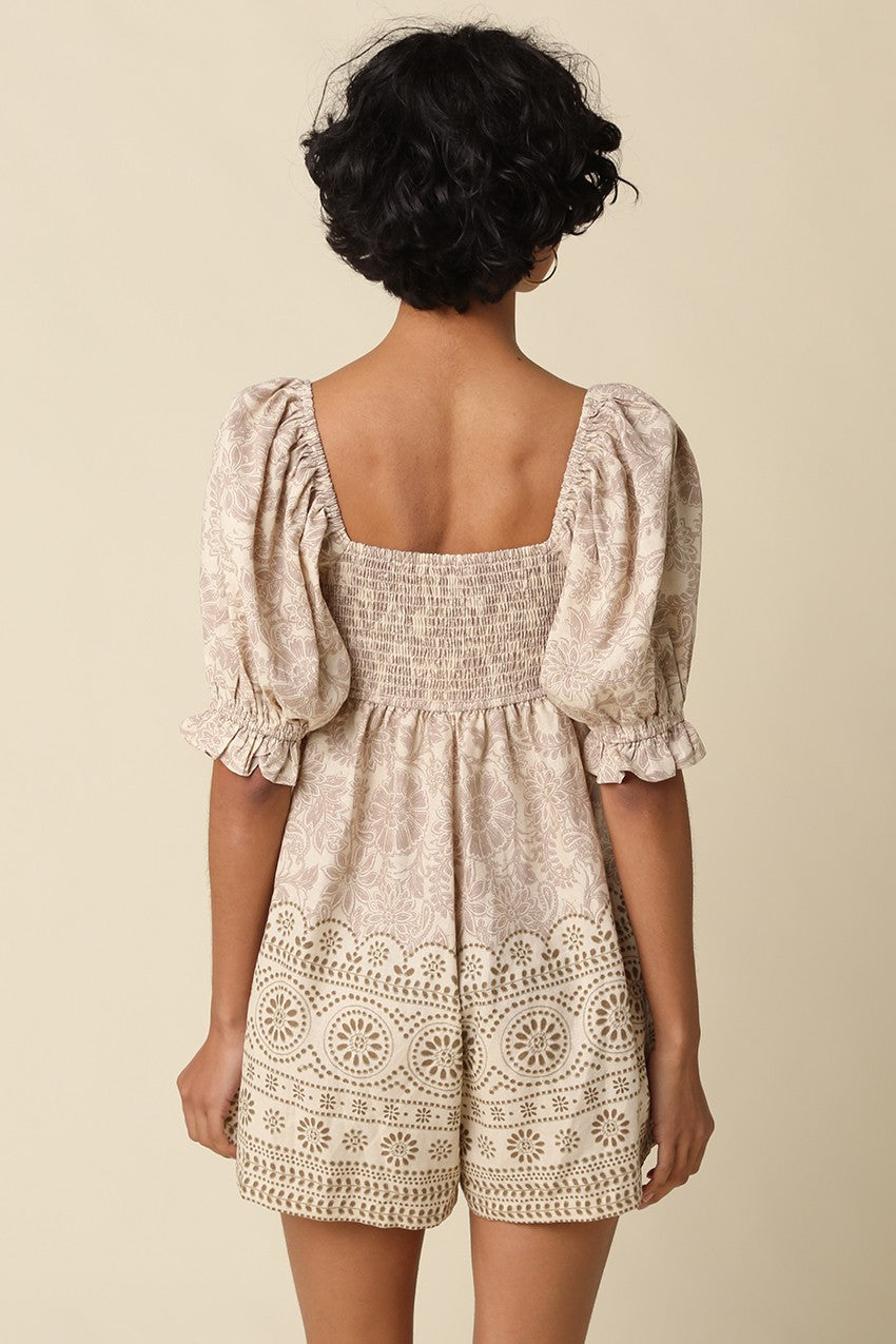 A breezy printed babydoll romper featuring a vintage-inspired print, square neckline, puff sleeves, and a flattering smocked back for effortless all-day style.
