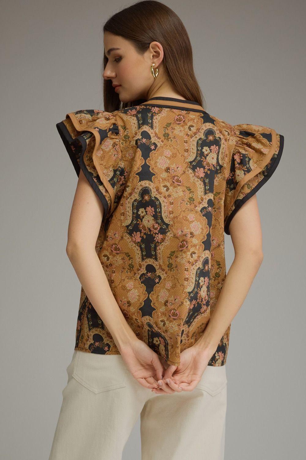 A feminine floral cotton top featuring romantic ruffle cap sleeves, contrast trim, and a flattering split neckline for effortless everyday elegance.