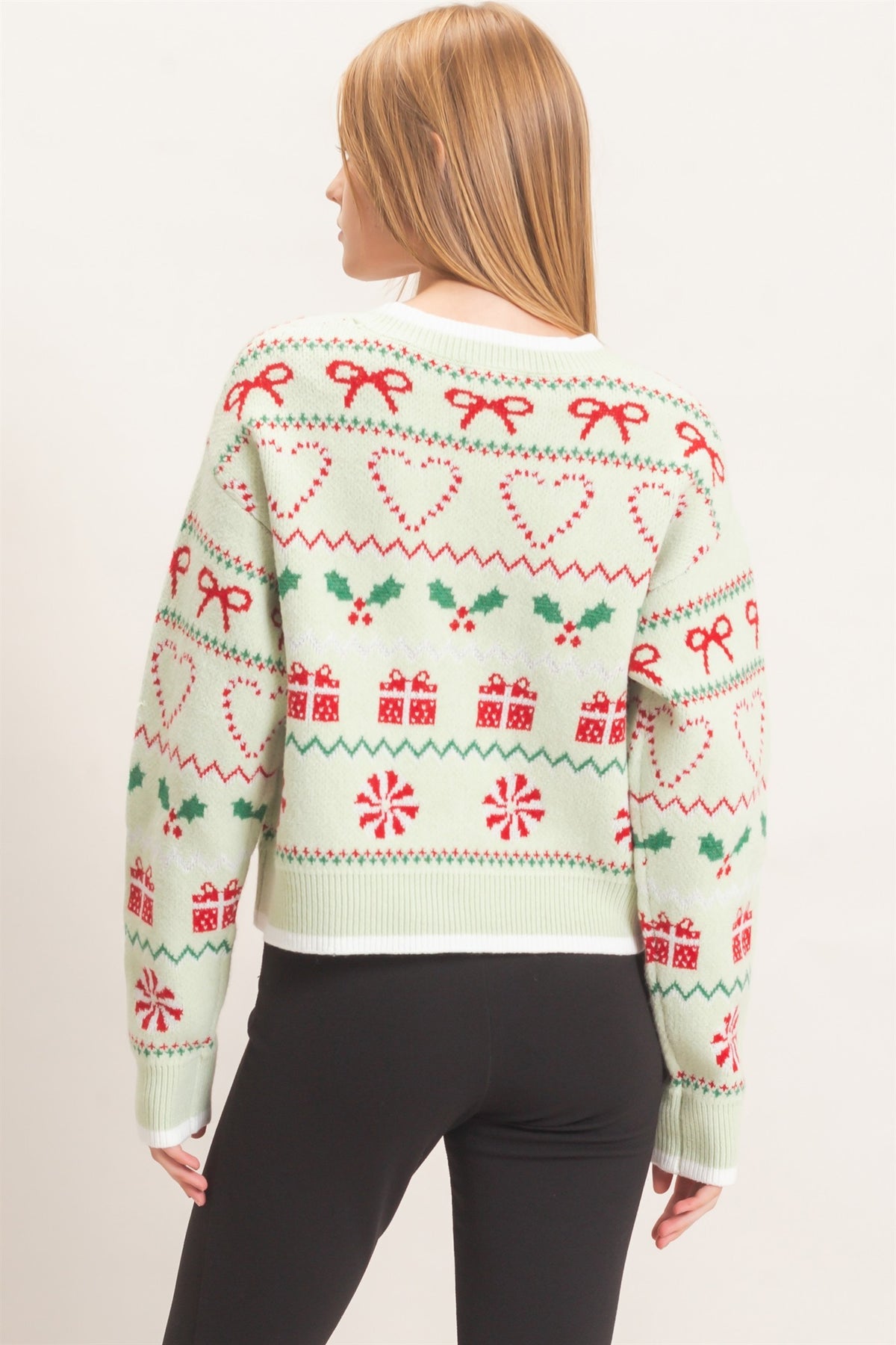 A festive cropped cardigan featuring a charming holiday jacquard pattern, classic button front, and polished contrast edging.

