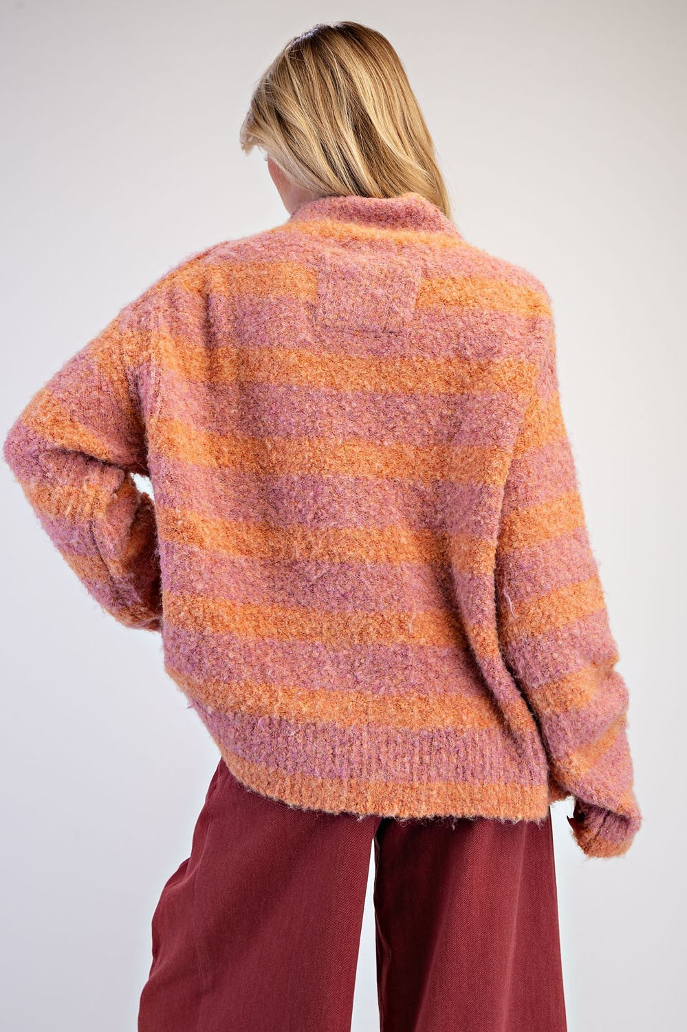 A cozy textured knit cardigan featuring a relaxed slouchy fit, dropped shoulders, and playful mismatched buttons for a unique finishing touch.