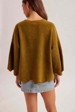 A cozy statement sweater featuring scalloped edges, dramatically wide sleeves, and cute pocket details for effortless everyday style.