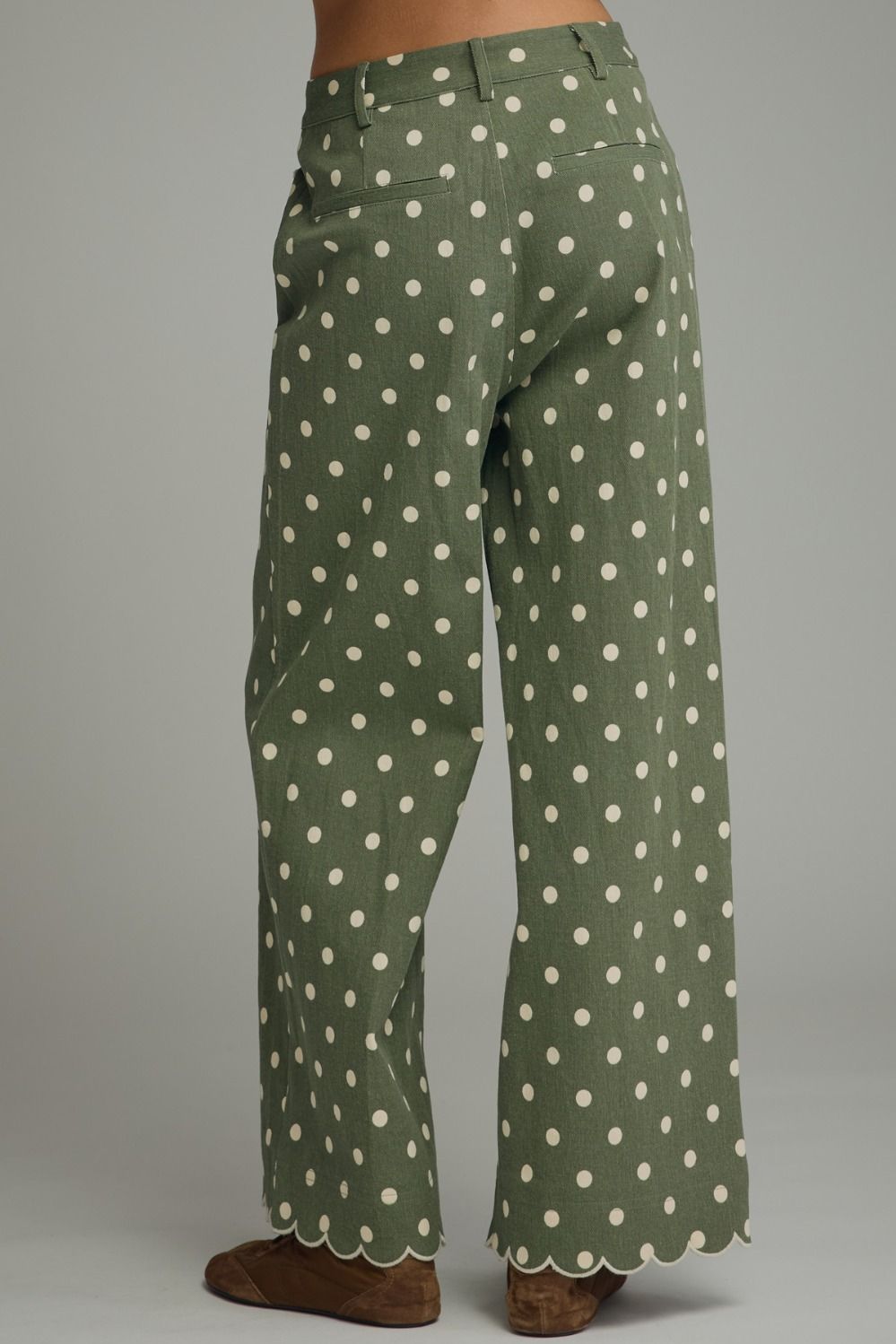 Playful polka dot wide-leg pants featuring scalloped embroidered trim and a polished button-front closure for a feminine, elevated look.