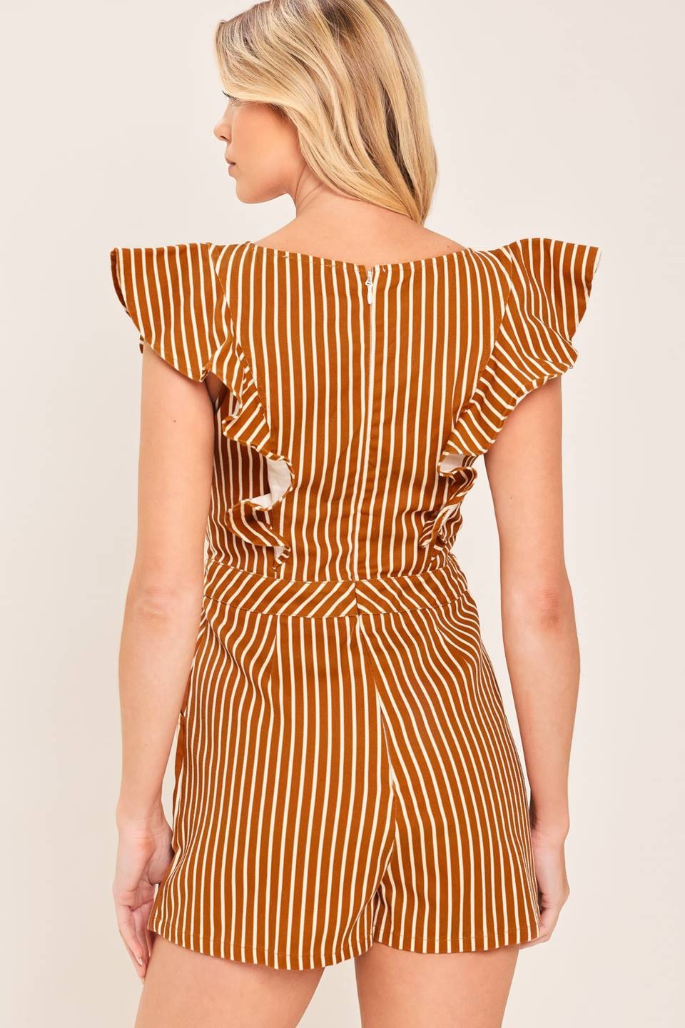 A playful printed skort romper featuring a feminine ruffle sleeve, classic round neckline, and easy back zipper closure for effortless one-and-done style.