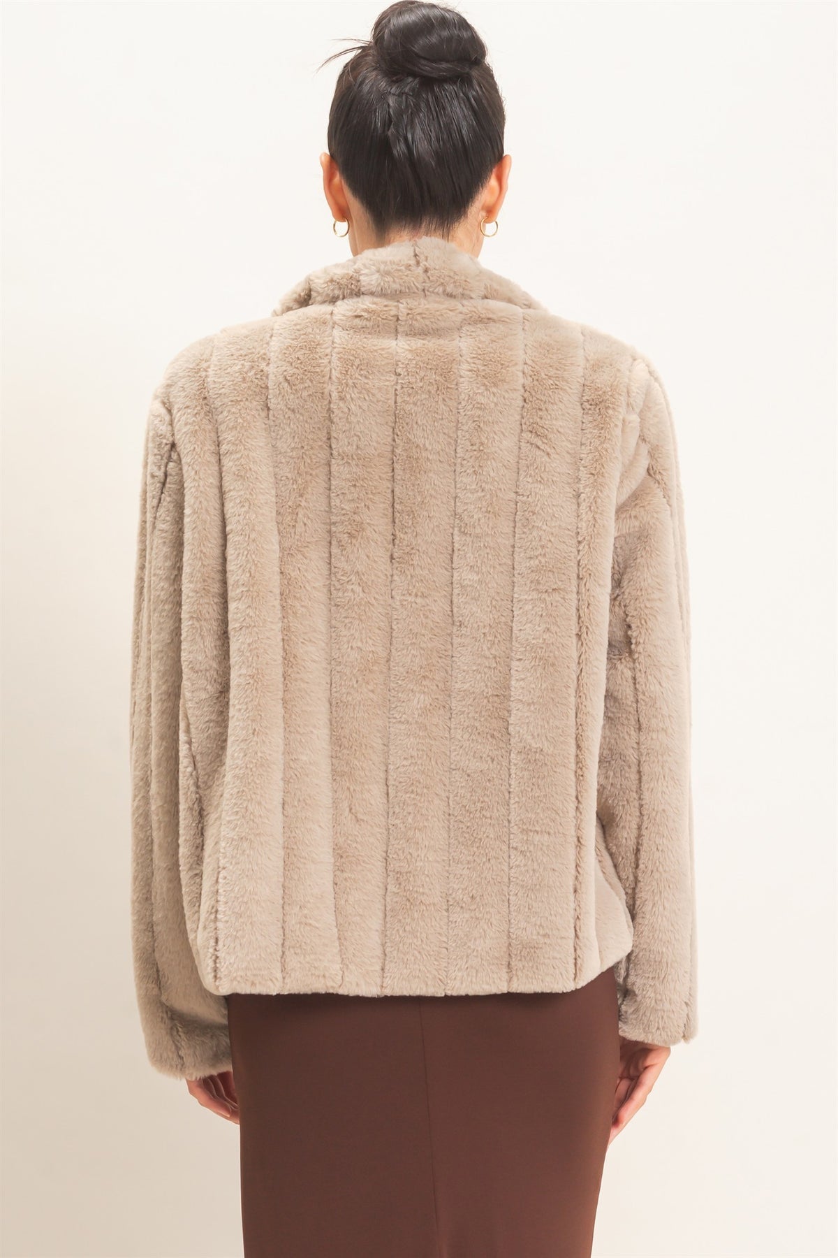 A luxurious faux fur jacket featuring a clean silhouette, cozy warmth, functional pockets, and an easy hook-and-eye front closure.

