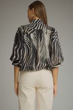 A statement-making zebra print top featuring elegant ¾ balloon sleeves, a stand collar, gathered details, and a polished banded hem.

