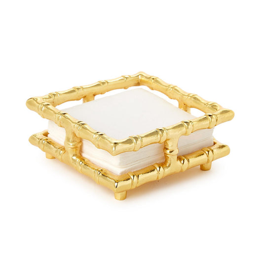 A square gold-toned bamboo-style notepad holder containing white paper notepads, photographed on a clean white background.
