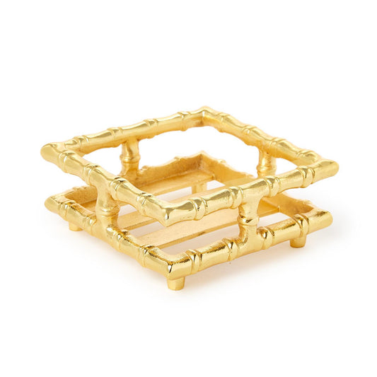 A gold-finished square bamboo-style tray or stand with a slatted open bottom, photographed on a clean white background.