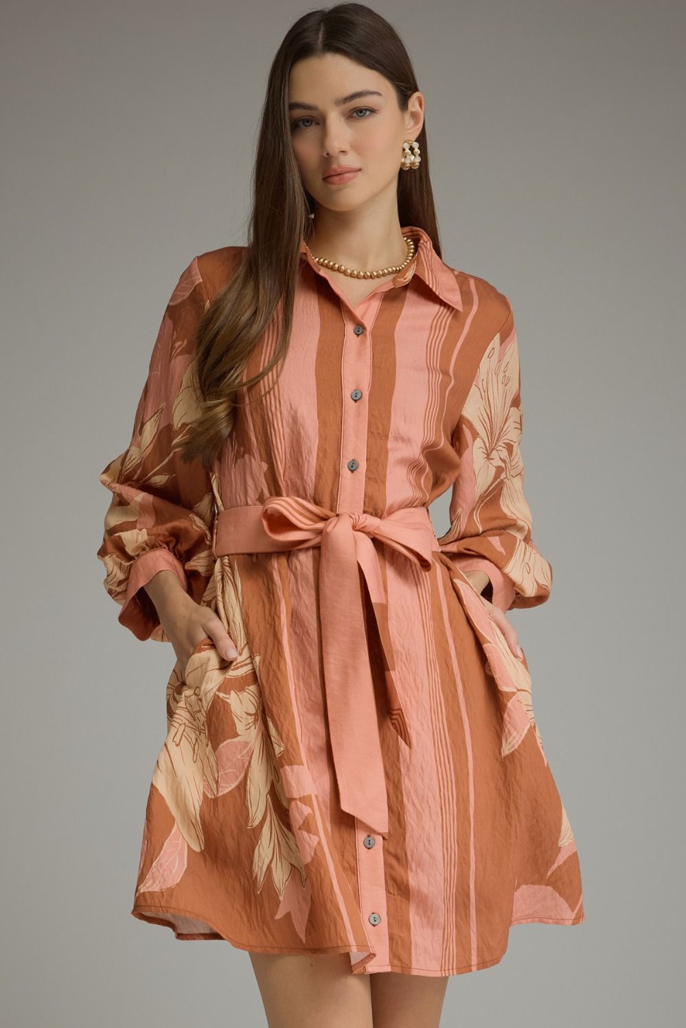 A feminine printed mini dress featuring dramatic balloon sleeves, a classic shirt collar, button-front closure, and a flattering self-tie waist.