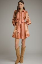 A feminine printed mini dress featuring dramatic balloon sleeves, a classic shirt collar, button-front closure, and a flattering self-tie waist.
