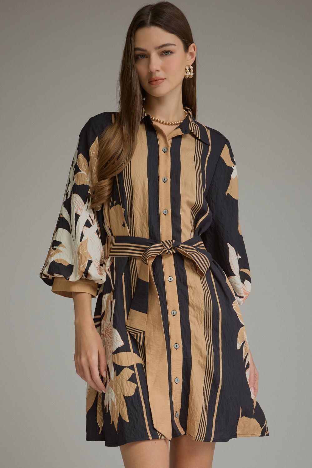 A feminine printed mini dress featuring dramatic balloon sleeves, a classic shirt collar, button-front closure, and a flattering self-tie waist.