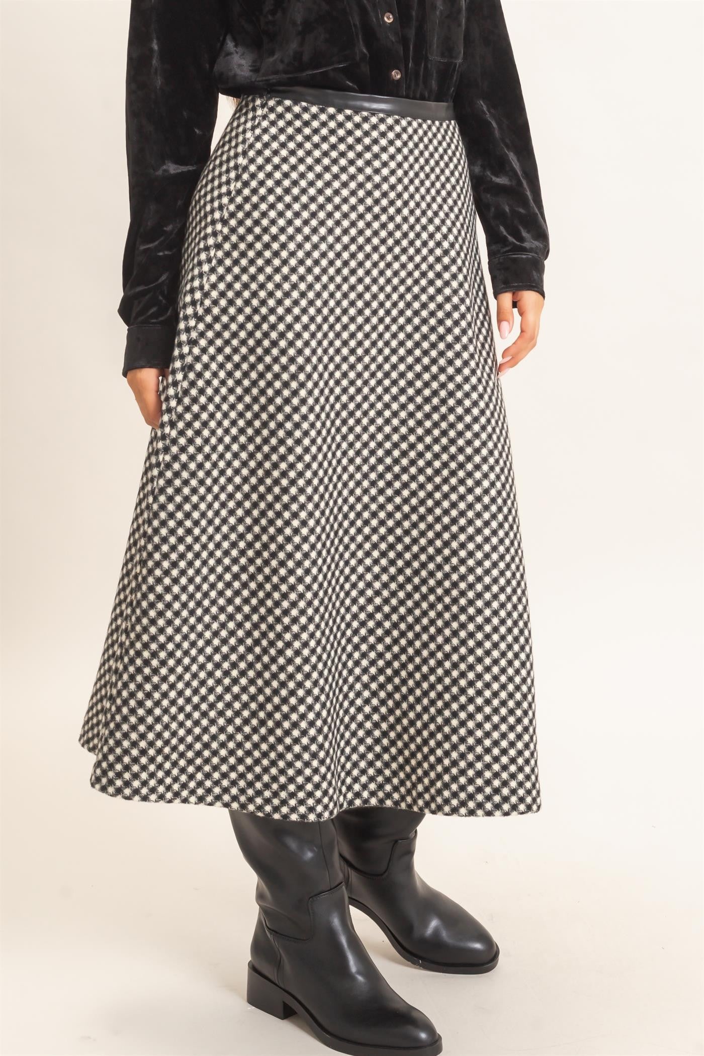 A sophisticated checkered A-line midi skirt featuring a sleek faux leather waistband and flattering flare for effortlessly polished style.
