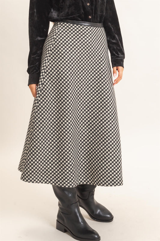A sophisticated checkered A-line midi skirt featuring a sleek faux leather waistband and flattering flare for effortlessly polished style.
