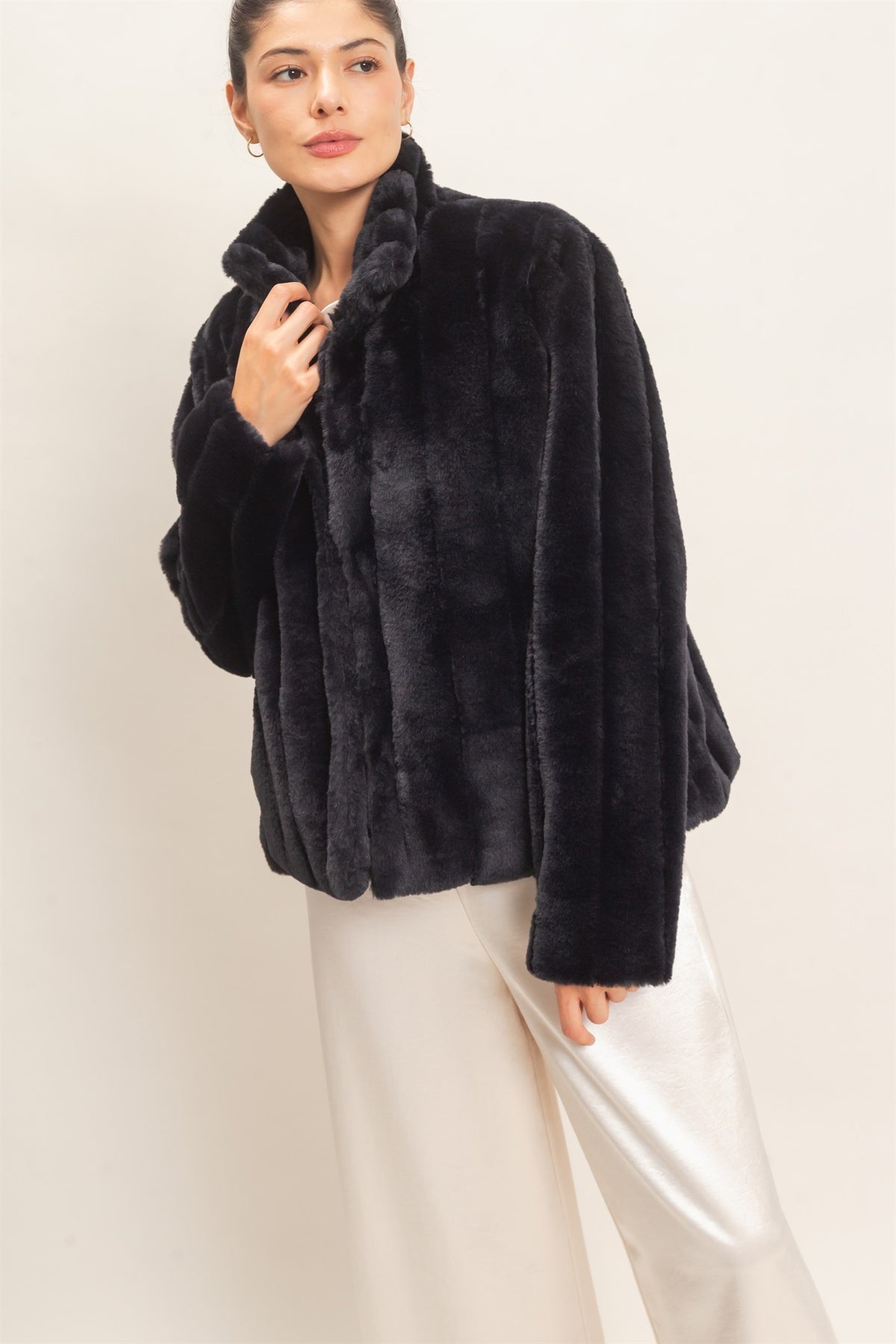 A luxurious faux fur jacket featuring a clean silhouette, cozy warmth, functional pockets, and an easy hook-and-eye front closure.


