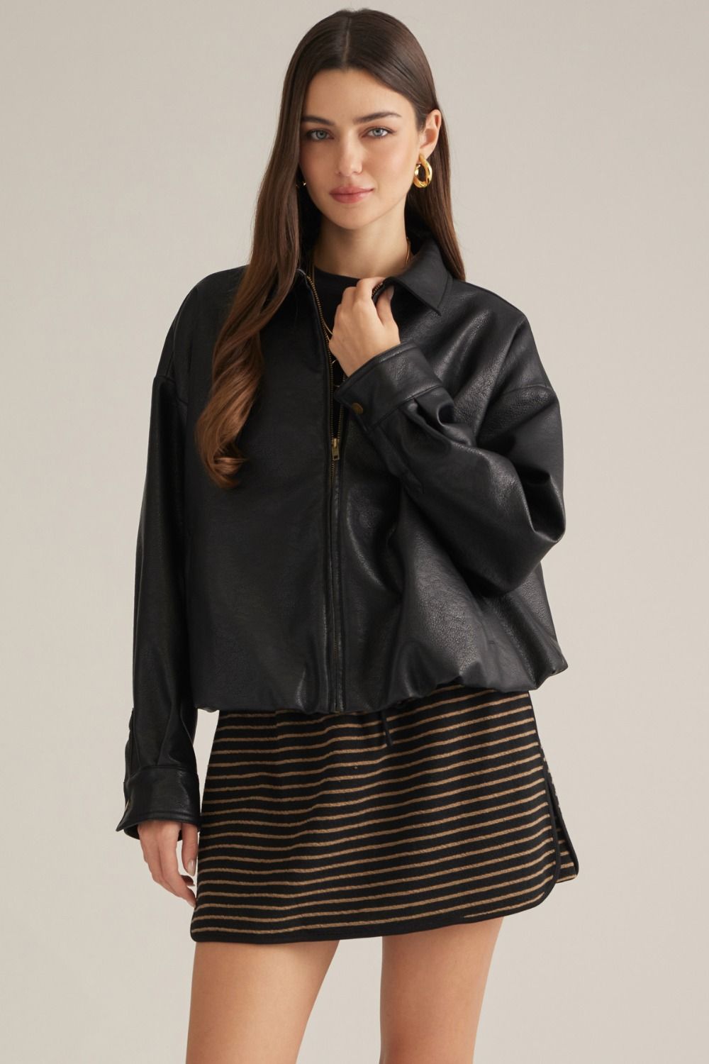 A sleek faux leather jacket featuring a classic shirt collar,bubble hem, front zipper, button cuffs, and practical side pockets for polished everyday style.