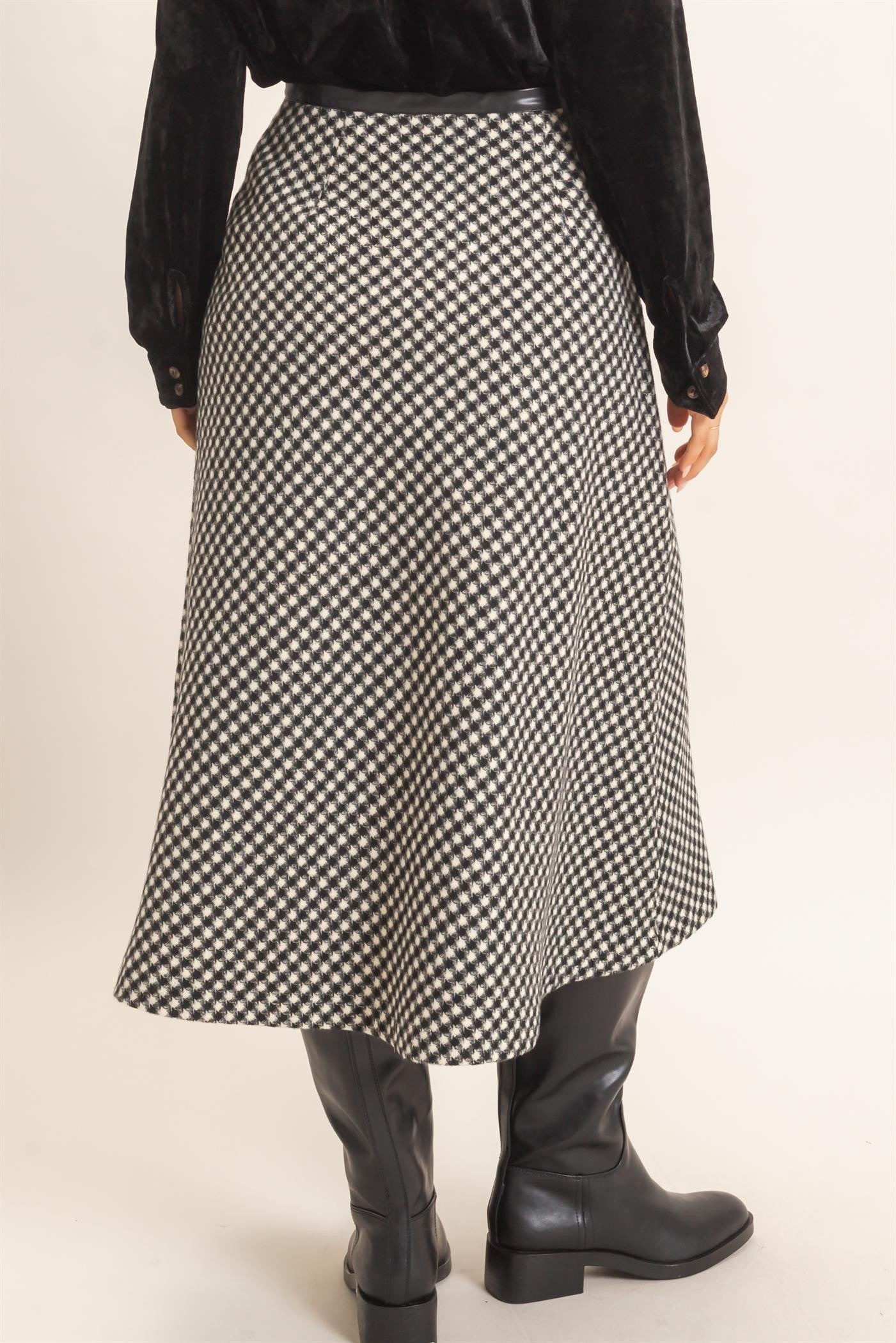 A sophisticated checkered A-line midi skirt featuring a sleek faux leather waistband and flattering flare for effortlessly polished style.
