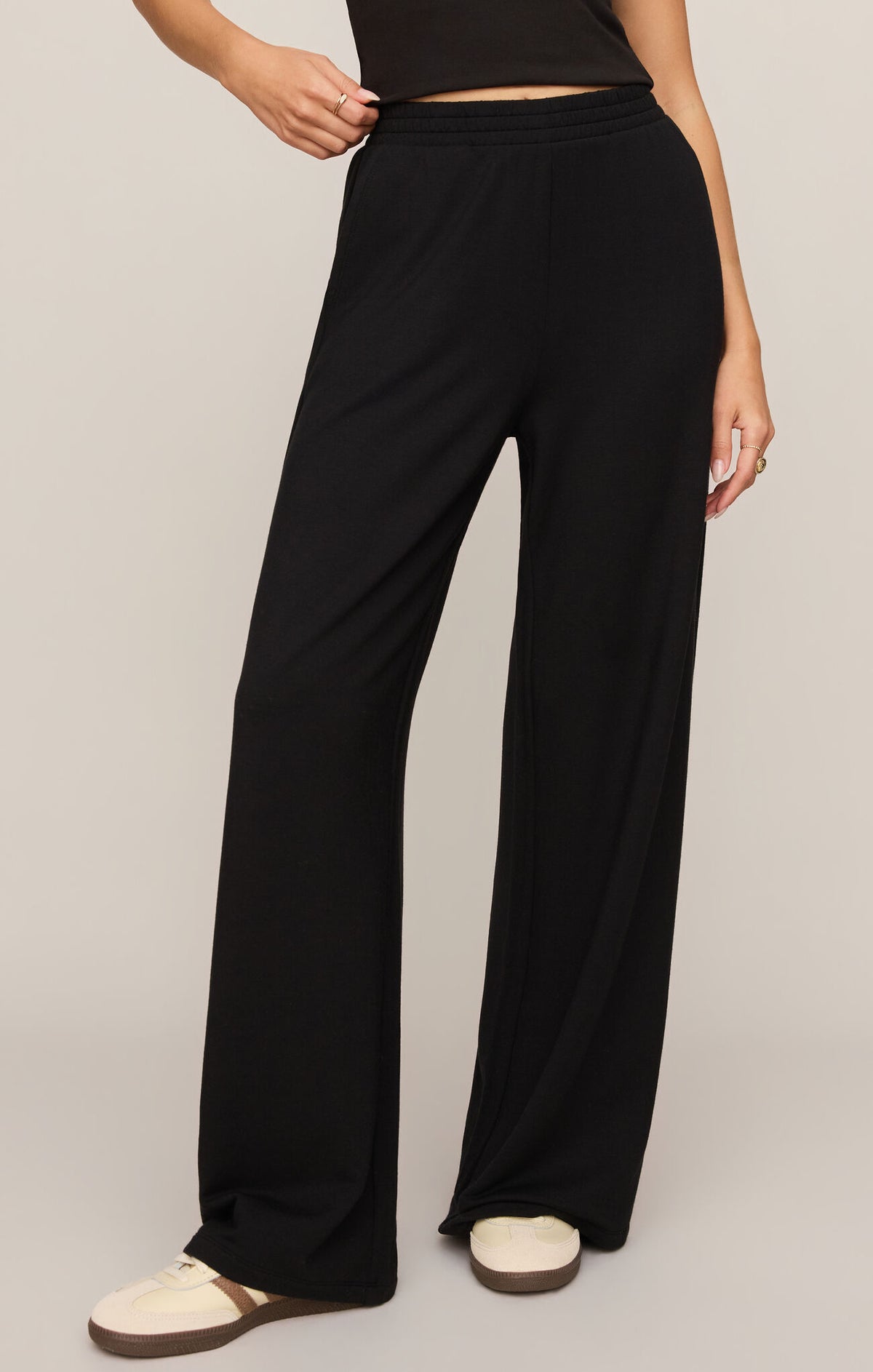 Person wearing black wide-leg pants on a plain background