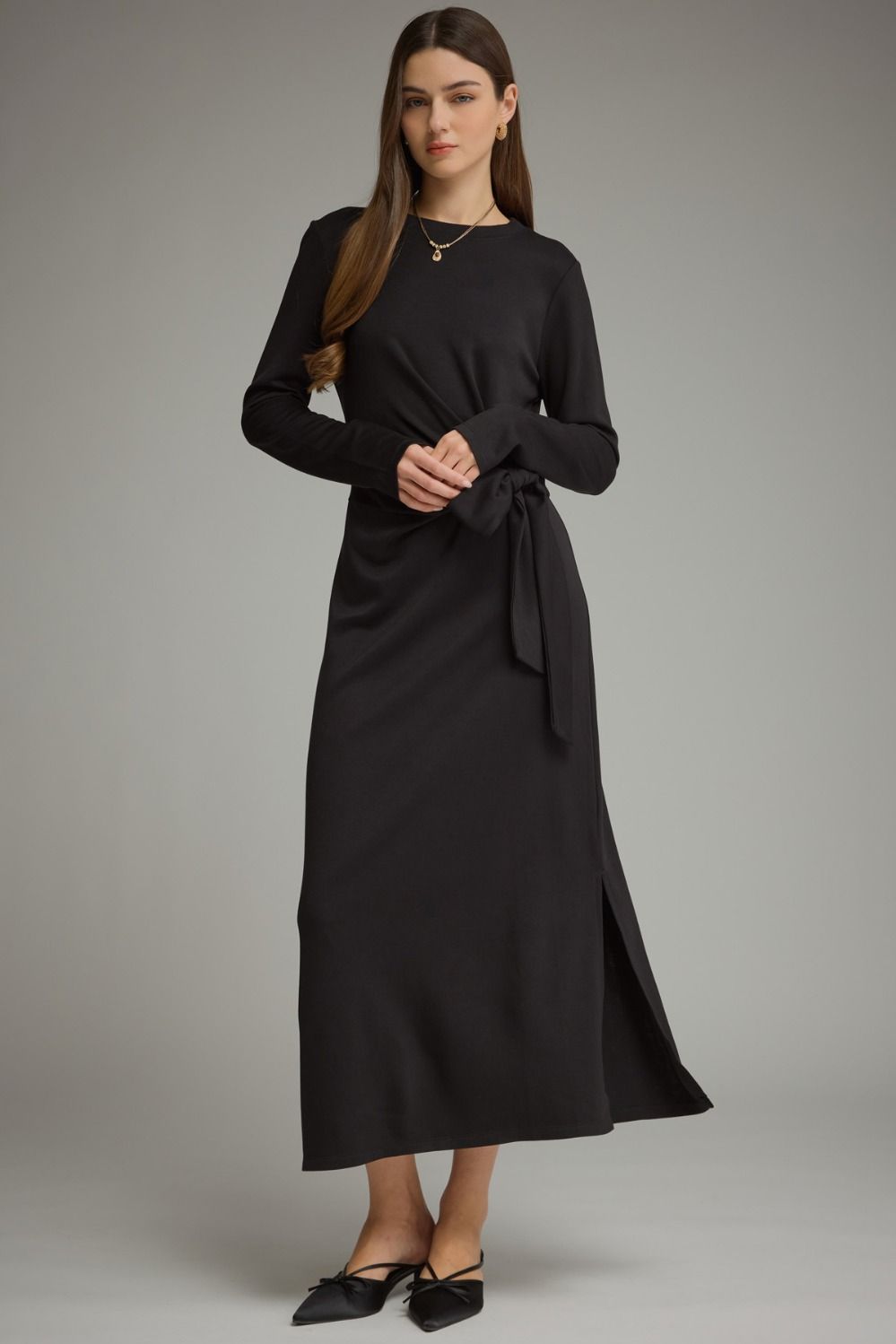 A sleek and effortlessly flattering long sleeve midi dress featuring a soft knit feel, adjustable side-tie waist, and chic side slit.