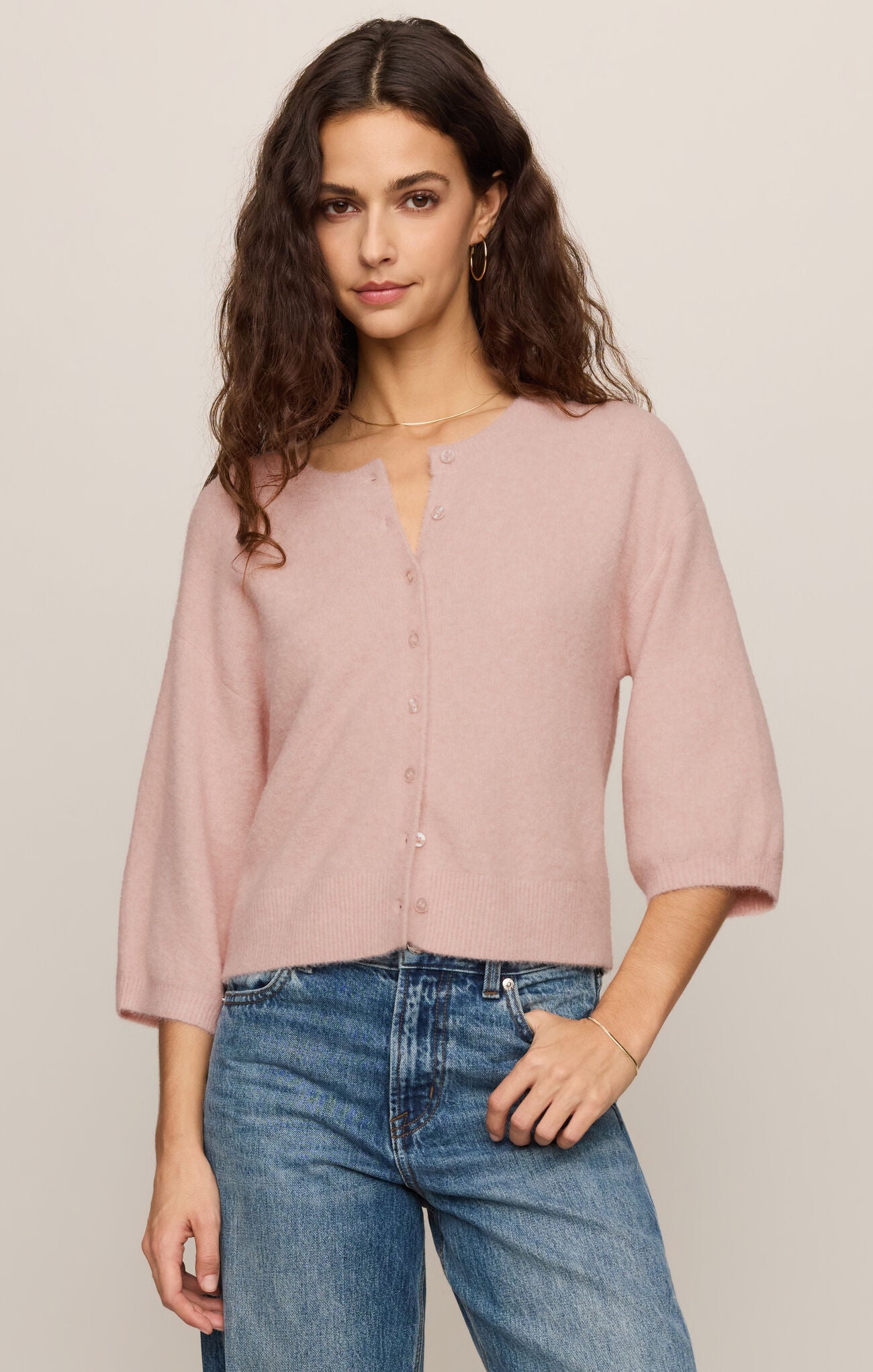 A soft knit button-front top featuring a classic crew neckline, ¾ sleeves, and a lightweight stretch fabric for effortless everyday layering.