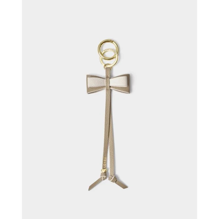 Our Bow Charm Keyring in Taupe features a sweet bow-shaped design, stamped with the sweet sentiment ‘Loved’. Finished with gold-tone signature charm detailing.
